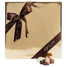 Gold chocolate gift box with brown ribbon bow, with a few assorted chocolates in front