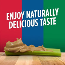 Creamy peanut butter on a green spreader with scattered peanuts