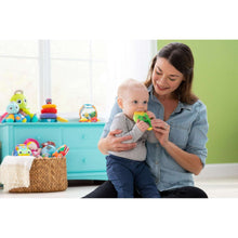 Corn teether toy held by baby, green and yellow