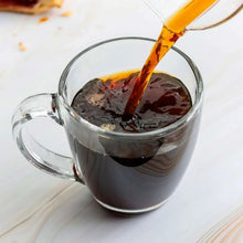 Cup of brewed dark coffee with stream pouring into mug