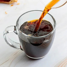 Cup of dark coffee with coffee being poured into the mug