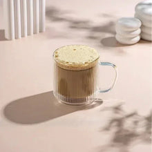 Fluted double-wall glass mug with amber coffee and frothy top, clear handle
