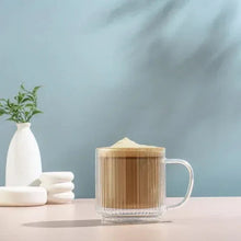 Fluted double-wall glass mug with amber coffee and frothy top, clear glass body
