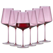 Set of 6 pink tinted wine glasses, one front glass filled with red wine