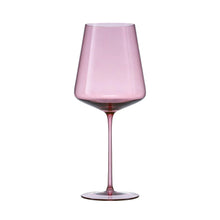 Pink tinted wine glass with red wine, rounded bowl and slender stem