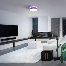 Round ceiling LED light casting purple glow in room