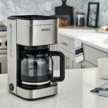 Stainless and black 10-cup drip coffee maker with closed lid and empty carafe