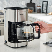 Stainless and black 10-cup drip coffee maker with glass carafe; hand grips handle