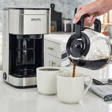 10-cup drip coffee maker with glass carafe, black brew basket, stainless body; coffee pours