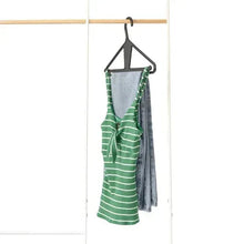 Clip-style hanger holding green and white striped garments on a dark frame