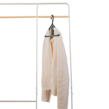 Clip-style hanger with beige towel on a black hanger frame