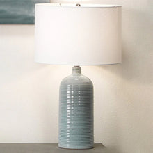 Table lamp with white fabric shade and blue ribbed glass base with metal stem
