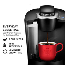 Keurig® single-serve coffee maker with red mug and coffee brewing stream
