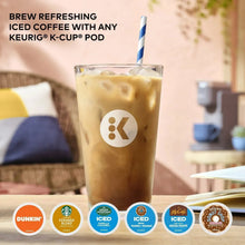 Iced coffee in clear glass with Keurig K logo and blue-striped straw