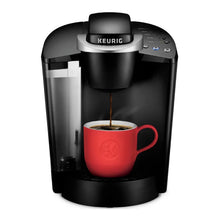 Keurig® single-serve coffee maker brewing into a red mug from the spout
