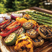 Grilled mixed vegetables on a wooden board with seasoning speckling