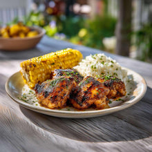 Plate of grilled chicken pieces with rice and corn