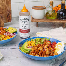 Sticky Honey BBQ wing sauce bottle with orange cap on a kitchen counter