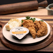 Honey Hot BBQ sauce cup with chicken and herbs on a plate