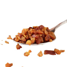 Spoonful of bacon crumbles, reddish-brown crumbled bits