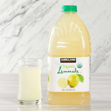 Organic lemonade bottle with green cap and glass of pale yellow drink