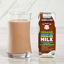 Organic reduced-fat chocolate milk carton beside glass of milk