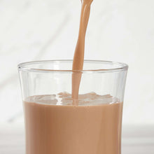 Chocolate milk pouring into a clear glass