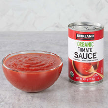 Organic tomato sauce can with glass bowl filled with red tomato sauce