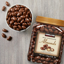 Milk chocolate almonds jar beside bowl of chocolate-coated almonds