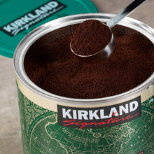 Coffee grounds in a spoon above a Kirkland Signature decaffeinated coffee can