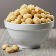 Dry roasted macadamia nuts in white bowl, golden roasted pieces