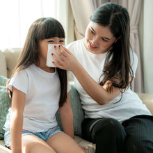 Facial tissues held by children and caregiver, tissues pulled from pack
