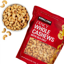 Whole cashews in white bowl beside red sea-salt cashew bag