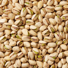 Dense pile of unsalted pistachios in cream shells with small green kernels