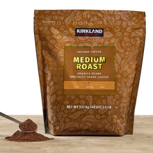 Kirkland Signature medium roast ground coffee bag with scoop and grounds, arabica beans.