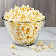 Glass bowl filled with popped popcorn kernels, butter-colored