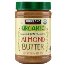 Creamy organic almond butter jar with green screw lid and front label text.