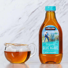 Organic blue agave nectar bottle with glass pitcher and amber drink