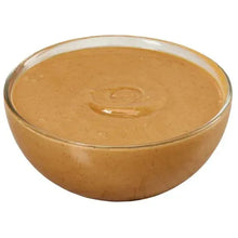Creamy peanut butter in glass bowl with smooth surface