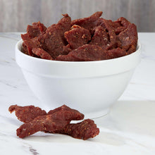 White bowl filled with extra thick cured steak strips, reddish-brown pieces