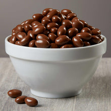 Milk chocolate covered raisins in white bowl, dark brown glossy pieces