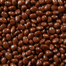 Milk chocolate covered raisins in close-up, glossy dark brown beans