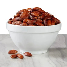 White bowl filled with roasted almonds with sea salt, brown almonds