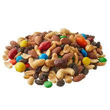 Trail mix pile of mixed nuts, raisins, and colorful candy pieces