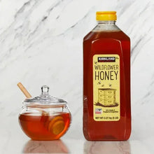 Kirkland Signature wildflower honey bottle and glass jar with honey, yellow cap