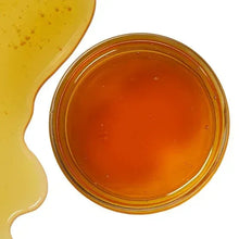 Wildflower honey surface in jar, amber color with slight ripples