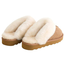 Pair of tan suede shearling slippers with plush cream straps and open backs