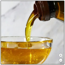 Pouring organic extra virgin olive oil into a glass bowl, golden oil