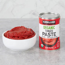 Organic tomato paste can with red tomato paste in a white bowl