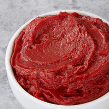 Close-up of red organic tomato paste texture in a white bowl